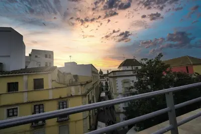 a view of a city at sunset from a balcony at Apartamentos Consistorio Live in Jerez de la Frontera