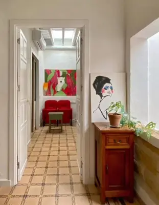 a hallway with red chairs and a painting on the wall at Botánico Casa Rural in Arcos de la Frontera