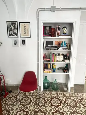a red chair in a room with a book shelf at Botánico Casa Rural in Arcos de la Frontera
