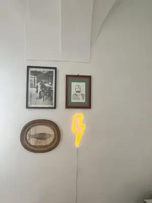 a wall with pictures and a yellow arrow on it at Botánico Casa Rural in Arcos de la Frontera