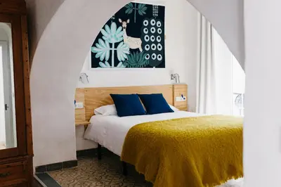 a bedroom with a bed with blue pillows at Botánico Casa Rural in Arcos de la Frontera