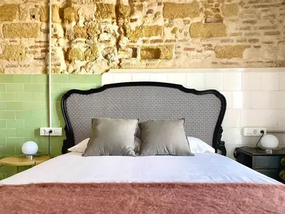 a bedroom with a bed and a brick wall at Botánico Casa Rural in Arcos de la Frontera