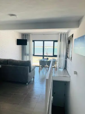 a living room with a couch and a table at Duplex ático Bajo de Guía in Sanlúcar de Barrameda