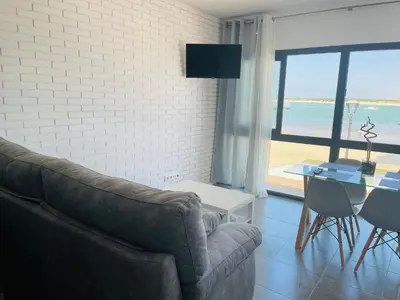 a living room with a couch and a table at Duplex ático Bajo de Guía in Sanlúcar de Barrameda