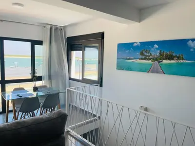 a living room with a view of the beach at Duplex ático Bajo de Guía in Sanlúcar de Barrameda