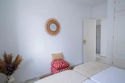 a white living room with a couch and a mirror at GINVA - Villa Puerto Sherry in El Puerto de Santa María