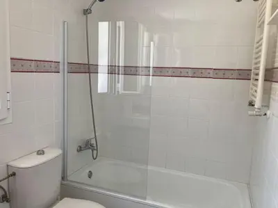 a bathroom with a toilet and a glass shower at GINVA - Villa Puerto Sherry in El Puerto de Santa María