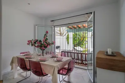 a dining room with a table with chairs and a balcony at GINVA - Villa Puerto Sherry in El Puerto de Santa María