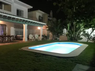a swimming pool in the yard of a house at night at GINVA - Villa Puerto Sherry in El Puerto de Santa María
