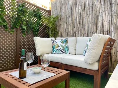 a couch on a patio with a table and wine glasses at GATU PREMIUM Sandia Beach lujo junto al mar, parking y piscina común,