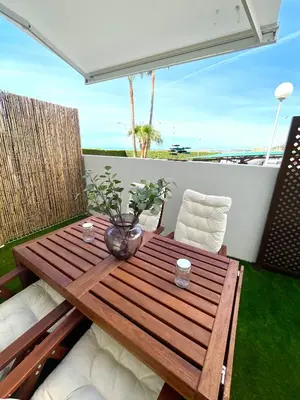 a wooden table and chairs on a balcony at GATU PREMIUM Sandia Beach lujo junto al mar, parking y piscina común,