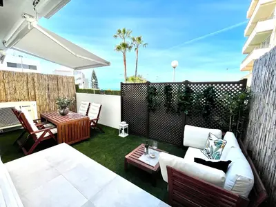 a patio with a white couch and a table at GATU PREMIUM Sandia Beach lujo junto al mar, parking y piscina común,
