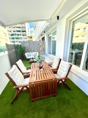 a patio with a table and chairs on a balcony at GATU PREMIUM Sandia Beach lujo junto al mar, parking y piscina común,