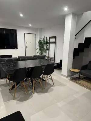a dining room with a black table and chairs at Villa Zeus in Rota