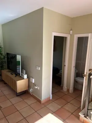 a living room with a tv and a toilet at Casa piscina Playa Barrosa Delfin 6 in Chiclana de la Frontera