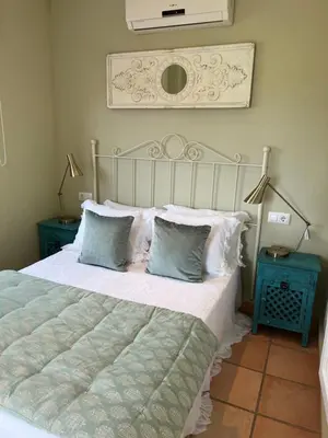 a bedroom with a large bed with two lamps and two tables at Casa piscina Playa Barrosa Delfin 6 in Chiclana de la Frontera