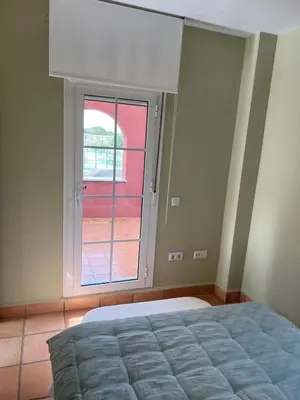 a bedroom with a bed and a large window at Casa piscina Playa Barrosa Delfin 6 in Chiclana de la Frontera