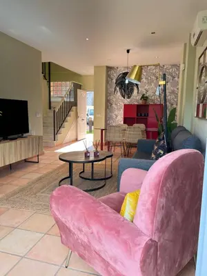 a living room with a pink couch and a table at Casa piscina Playa Barrosa Delfin 6 in Chiclana de la Frontera
