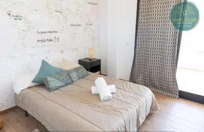 a bedroom with a large bed with towels on it at Elcano Village by Sanlucar Housing in Sanlúcar de Barrameda