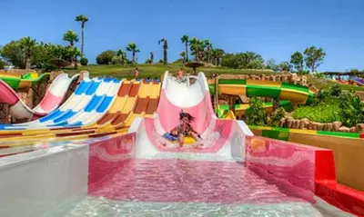 a person riding a water slide at a water park at Elcano Village by Sanlucar Housing in Sanlúcar de Barrameda
