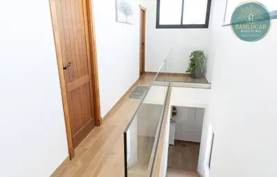 a glass staircase in a house with a door at Elcano Village by Sanlucar Housing in Sanlúcar de Barrameda