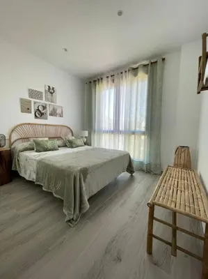 a bedroom with a large bed and a window at Exclusivo chalet en urbanización Roche in Conil de la Frontera