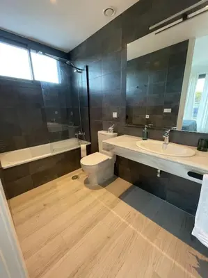 a bathroom with a toilet and a sink and a mirror at Exclusivo chalet en urbanización Roche in Conil de la Frontera