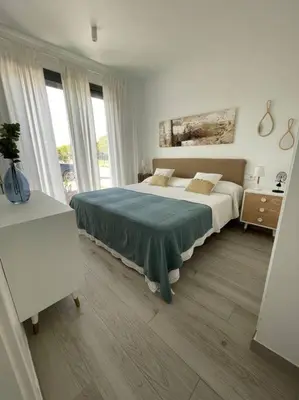 a white bedroom with two beds and windows at Exclusivo chalet en urbanización Roche in Conil de la Frontera