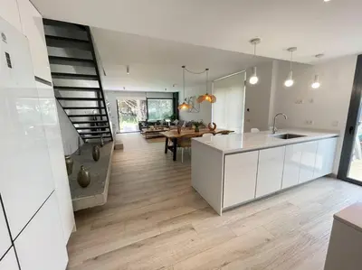 a kitchen and living room with a staircase in a house at Exclusivo chalet en urbanización Roche in Conil de la Frontera