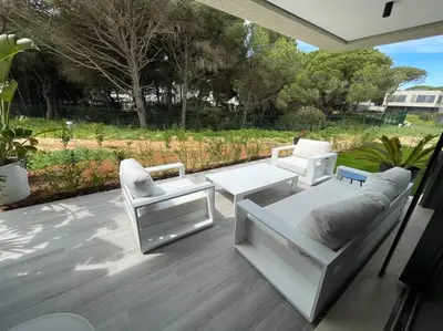 a patio with a couch and two chairs and a table at Exclusivo chalet en urbanización Roche in Conil de la Frontera