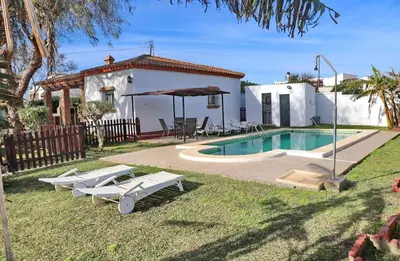 a villa with a swimming pool and a house at Chalet Verde Agua in Conil de la Frontera
