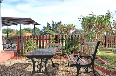 a patio with a table and chairs and an umbrella at Chalet Verde Agua in Conil de la Frontera