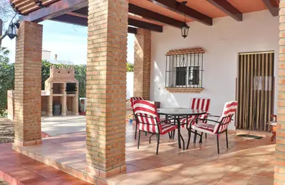 a patio with a table and chairs on a patio at Chalet Verde Agua in Conil de la Frontera