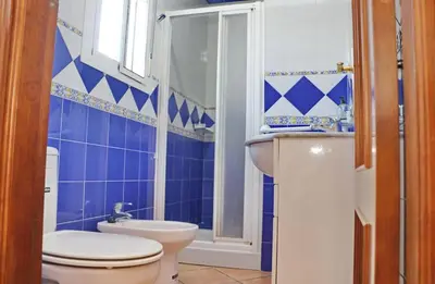 a blue and white bathroom with a toilet and a sink at Chalet Verde Agua in Conil de la Frontera