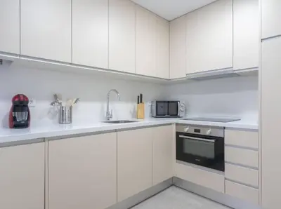 a white kitchen with white cabinets and a microwave at Apartoyou - Plaza de Toros in El Puerto de Santa María