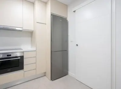 a kitchen with white cabinets and a refrigerator at Apartoyou - Plaza de Toros in El Puerto de Santa María