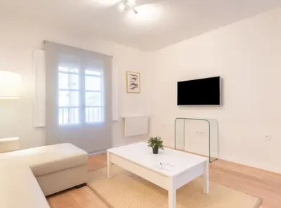 a living room with a white couch and a table at Apartoyou - Plaza de Toros in El Puerto de Santa María