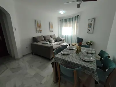 a living room with a table and a couch at Casita de la Infanta by Sanlúcar Housing in Sanlúcar de Barrameda