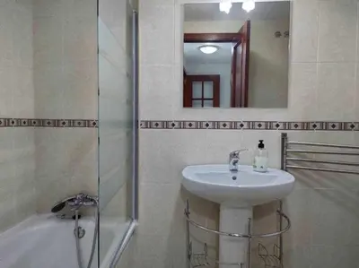 a bathroom with a sink and a mirror and a tub at Casita de la Infanta by Sanlúcar Housing in Sanlúcar de Barrameda
