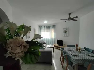 a living room with a couch and a vase of flowers at Casita de la Infanta by Sanlúcar Housing in Sanlúcar de Barrameda