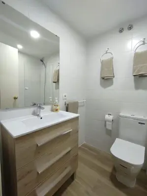 a bathroom with a sink and a toilet and a mirror at Apartamento en Puerto de Santa María, Playa Las Redes in El Puerto de Santa María