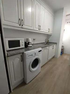 a kitchen with a washing machine and a microwave at Apartamento en Puerto de Santa María, Playa Las Redes in El Puerto de Santa María