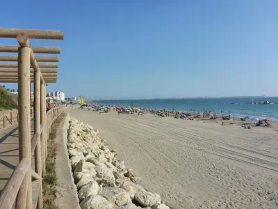 a beach with a fence and a bunch of people at Apartamento en Puerto de Santa María, Playa Las Redes in El Puerto de Santa María
