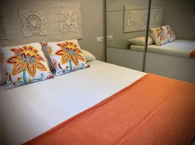 a bedroom with a bed with pillows and a mirror at MyChoice Toledo in Rota