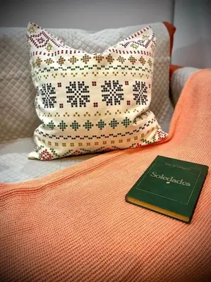 a book sitting on top of a couch with a pillow at MyChoice Toledo in Rota