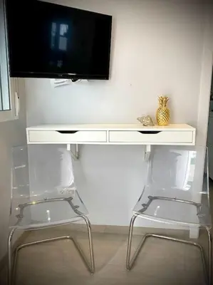 a desk with a tv on a wall with two chairs at MyChoice Toledo in Rota