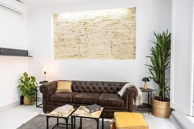 a living room with a brown leather couch at La Casa del Mercader by Gades Gestión in Cádiz