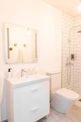 a white bathroom with a sink and a toilet at La Casa del Mercader by Gades Gestión in Cádiz