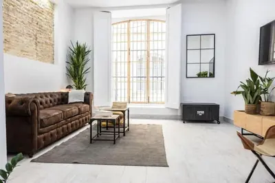 a living room with a brown couch and a table at La Casa del Mercader by Gades Gestión in Cádiz