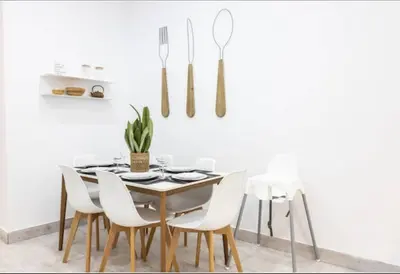 a dining room with a table and white chairs at La Casa del Mercader by Gades Gestión in Cádiz